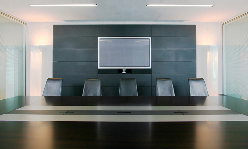 Konferenzraum mit großem Tisch und Bildschirm